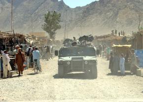 U.S. troops roll through a village marketplace in Kandahar province