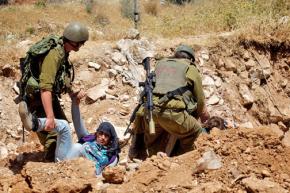 Israeli troops arrest protesters sitting in against the construction of the apartheid wall